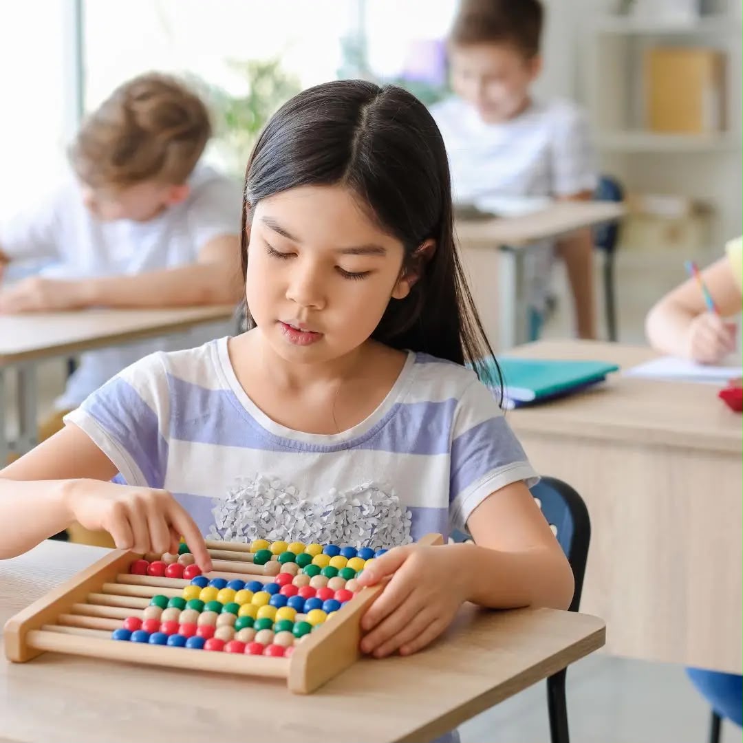 Enfant utilisant un boulier Montessori pour développer sa concentration et apprendre à compter