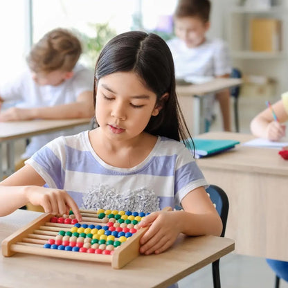 Enfant utilisant un boulier Montessori pour développer sa concentration et apprendre à compter