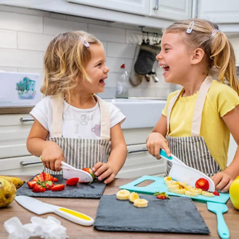 Deux enfants utilisant un kit cuisine enfant sécurisé pour couper des fruits en s’amusant