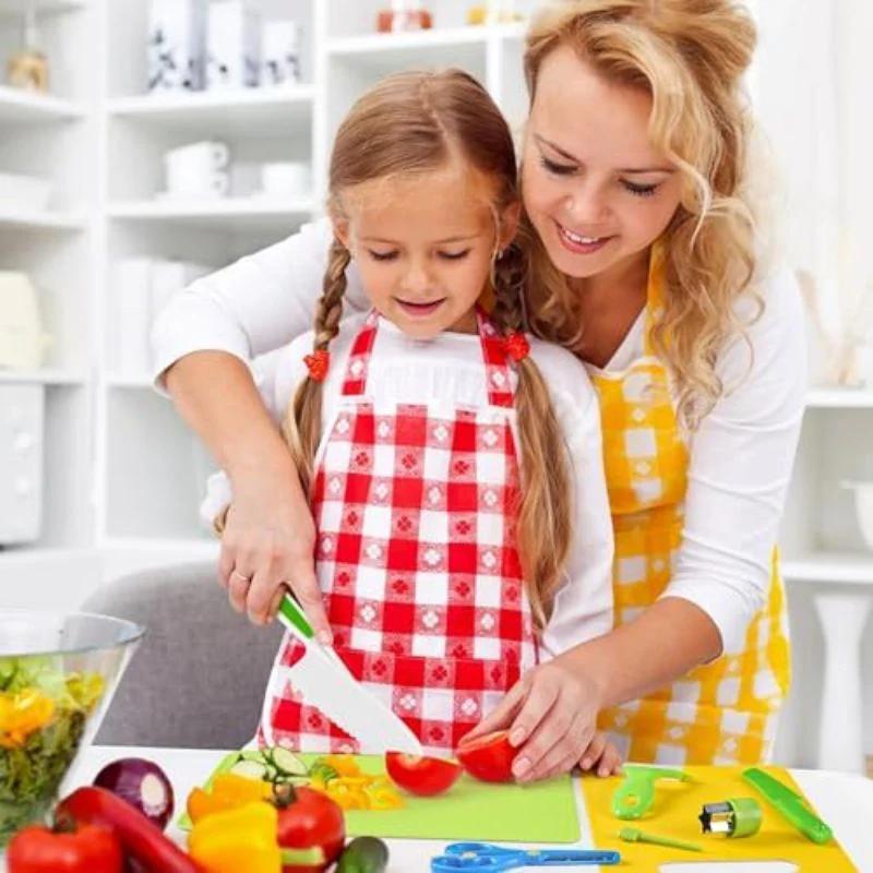 Maman et enfant utilisant un kit cuisine enfant sécurisé pour préparer des légumes ensemble